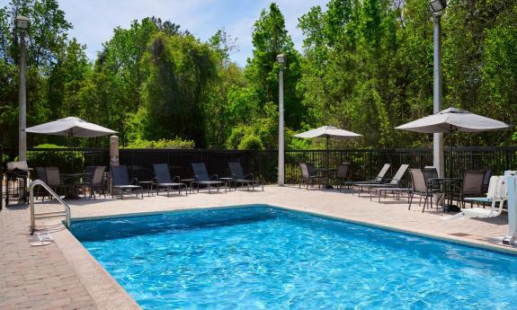 An outdoor pool with chairs surrounding it
