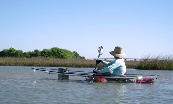A kayaker in a transparent kayak with a view of Vilano Bridge