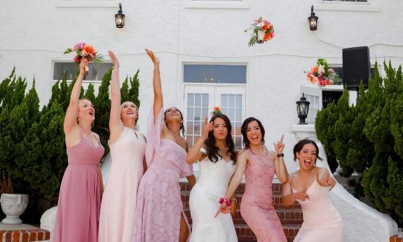 A bride and her bridesmaids throwing their bouqets