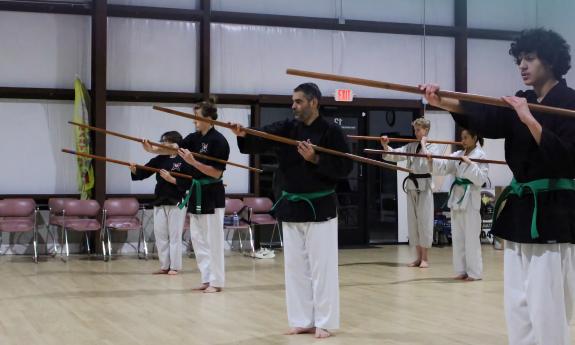 An older class using sticks in unison