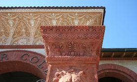 A close up of a pillar at the entranceway of the Hotel Ponce de Leon in St. Augustine, Florida. It is orange terra cotta and has the face of a lion carved into it.