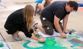 Street artists at the Paseo Pastel event working hard to complete their chalk art.
