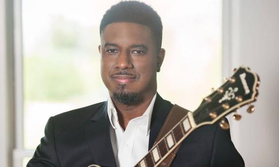 Clay Benjamin in a photo shoot with his guitar