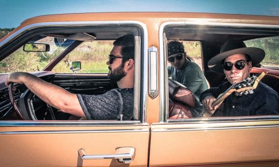 Honey Hounds in a car with their instruments