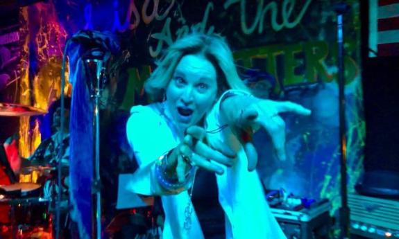 Lisa singing and pointing at the camera 