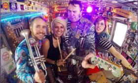 Igor and Red Elvises standing together with their instruments for a group photo