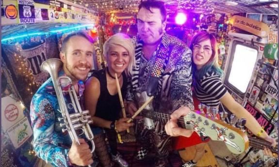 Igor and Red Elvises standing together with their instruments for a group photo