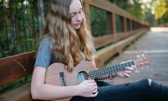 Amelia Evans playing her guitar