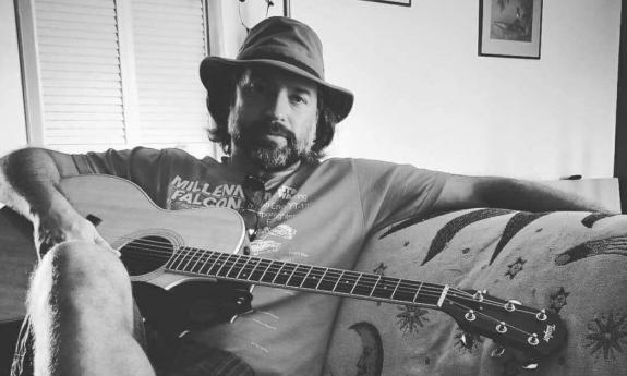 Jory Lyle sitting with his guitar