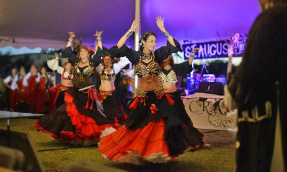 Visitors to the pirate festival watch dancers perform at a dinner.