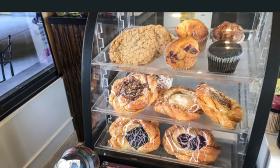 Baked pastries, danishes, and muffins sit in a case at Reflections Bistro.
