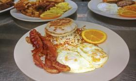 Breakfast plate from Georgie's Diner featuring fried eggs, bacon, and hash browns