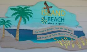 A beachy sign advertising the eatery and souvenir shop