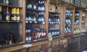 A wooden shelf full of wine 