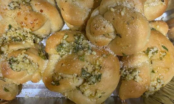 Garlic knots topped with seasoning and parmesan cheese