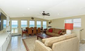 The living room of a Florida Rentals beach house in St. Augustine FL, which is furnished by plush couches and a dining room table
