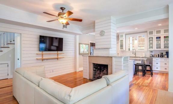 The wood-paneled “Romantic Getaway” property in historic downtown St. Augustine is furnished with a white interior and a full kitchen