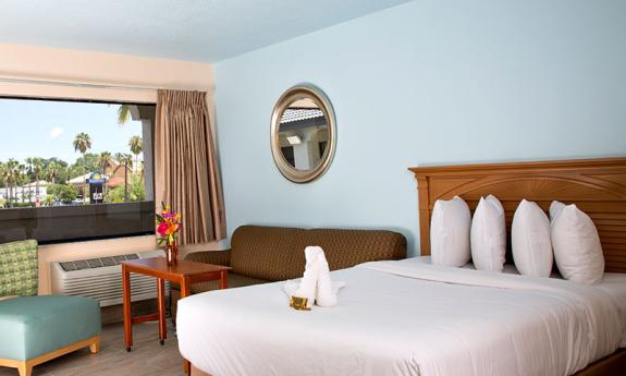 A guest bedroom at the Ponce Hotel with breezy design, and a window with a view.