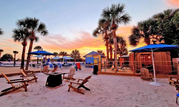 The sundeck features a pool with deck, an asado grill, Tiki Bar, and sandy area with a fire pit at Guy Harvey Resort St. Augustine Beach.