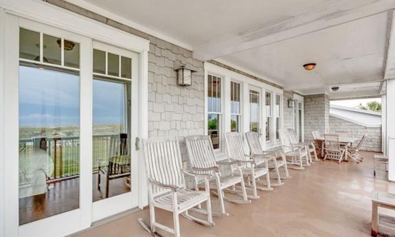 Guests can relax and rock on the southern-style deck at this Linda's Beach Rental in St. Augustine.