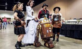 Steampunk cosplayers dressed up as Star Wars characters with a steampunk R2D2 droid.