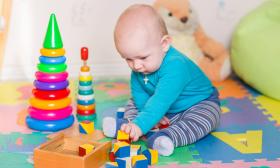 Infant playing with blocks and other toys