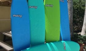A line of blue and green surfboards waiting for the waves in St. Augustine.
