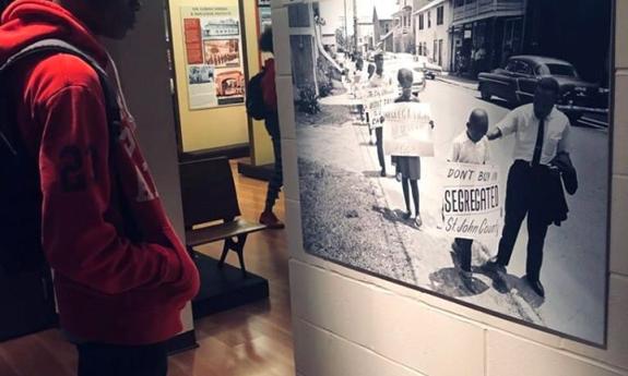 A visitor to the Lincolnville Museum and Cultural Center gazes at an image of Dr. King and a child at a segregation protest in St. Augustine.