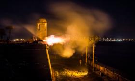 A rare nighttime cannon firing demonstration over the bayfront