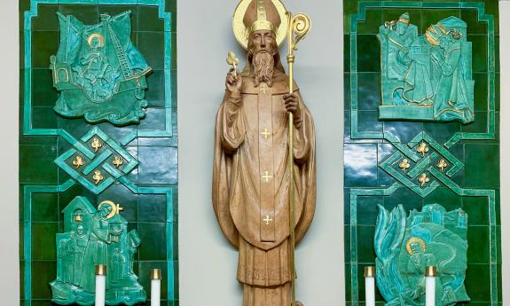 A close-up of the chapel of Saint Patrick in the Cathedral Basilica of Saint Augustine in St. Augustine, Florida. This chapel is a nod to the Irish history of the Cathedral Basilica, which has had many Irish bishops throughout its history. The hand-carved wooden sculpture of St. Patrick is backed by green-stone scenes that depict scenes from the saint’s life. 