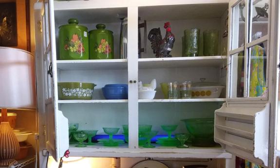 A kitchen cabinet with vintage items, all for sale at Cool and Collected in St. Augustine.