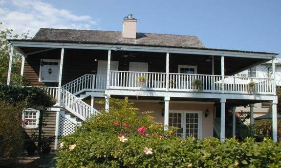 The exterior of the Casa de Solana from its lush courtyard on St. Augustine's historic Aviles Street. It is a two-story building with an upper deck 