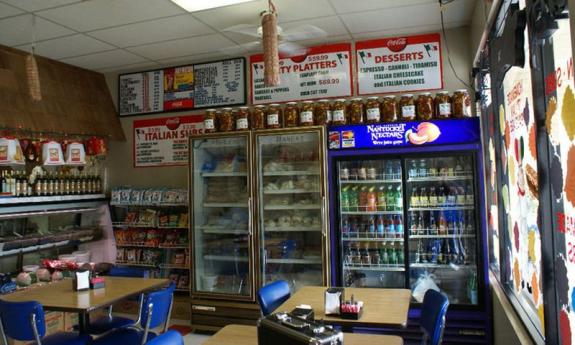 The inside of the shop has soft drinks, Italian groceries, and subs available