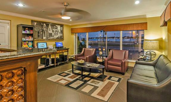 The welcoming lobby of the Best Western Bayfront in St. Augustine FL. The room has several couches, a large window facing Matanzas Bay, and hotel amenities