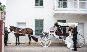 A groom assisting his bride into a white carriage in St. Augustine. 