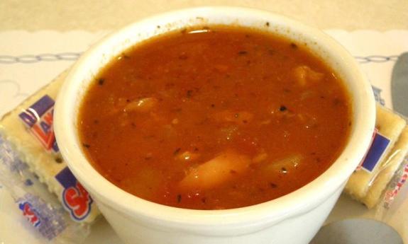 A bowl of Minorcan clam chowder with crackers on either side