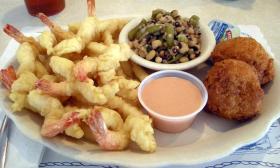 A fried shrimp platter with hushpuppies and green beans on the side