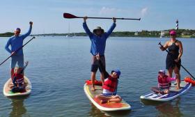 Parents and kids enjoying a paddle on a SUP with Kayaking St. Augustine.
