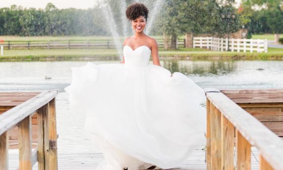 A bride celebrating her day beside the pond fountain at Kelly Farm Events. Photographer Christine Austin Photography.