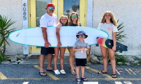 A family of surfers outside Mangrove Surf + Supply in St. Augustine.