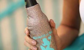 Soft gold glitter koozy with mermaid decal on it.