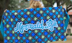 Mermaid Life towel with fin scales pattern on it in blue, teal, and green.