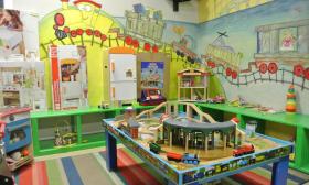 The children's playroom with the train table and kitchen set