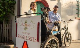 Two passengers aboard Pineaple Ride and Tour's pedicab in St. Augustine.