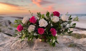 A rose bouquet created by The Potting Shed, and sitting on the beach in St. Augustine.