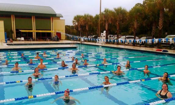 Swimmers hanging out in the pool during a practice