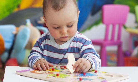 Young child putting together a puzzle