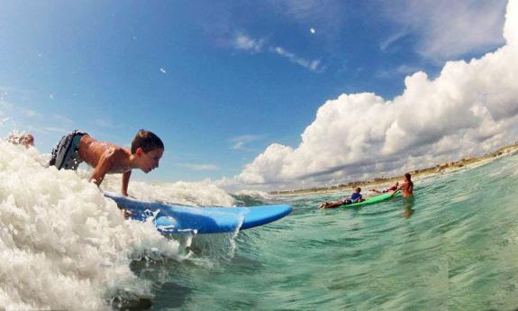 Boy gets up on a surf board