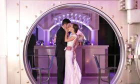 A bridal couple kiss in front of the Vault bar at the Treasury on the Plaza 