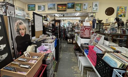 Records, posters, and paintings are displayed around the shop